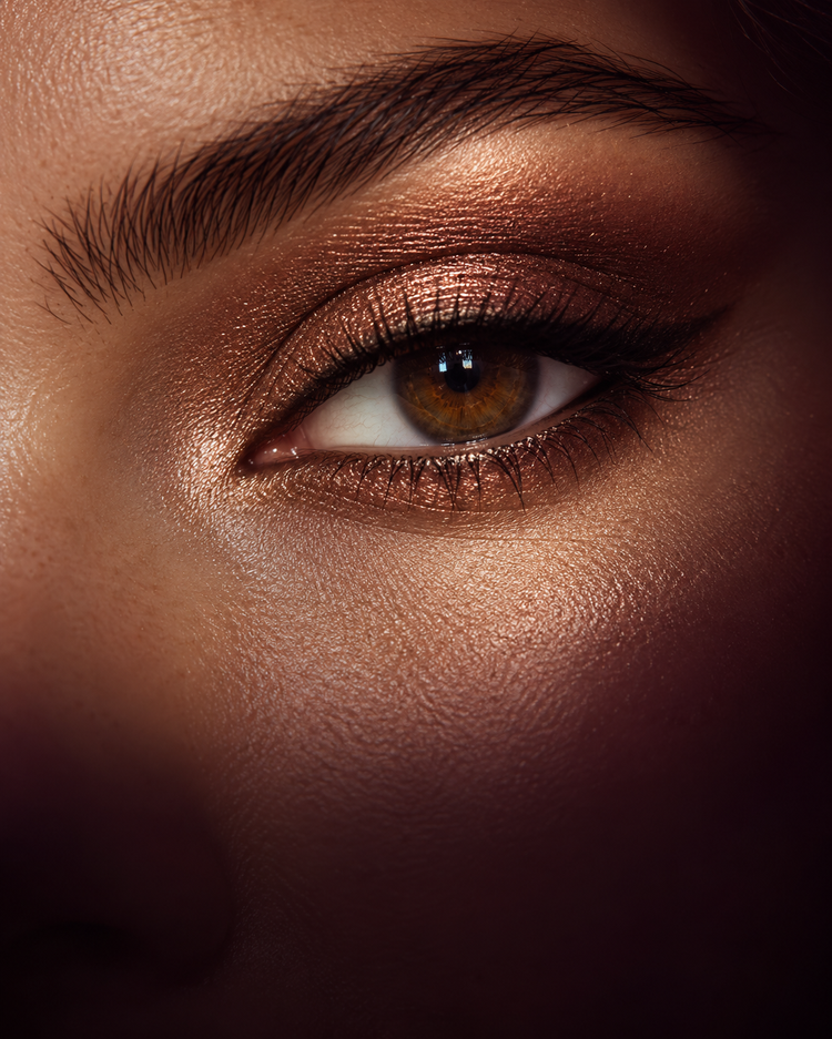 Ambiente editorial de una mirada marrón con sombra bronce y reflejos cálidos